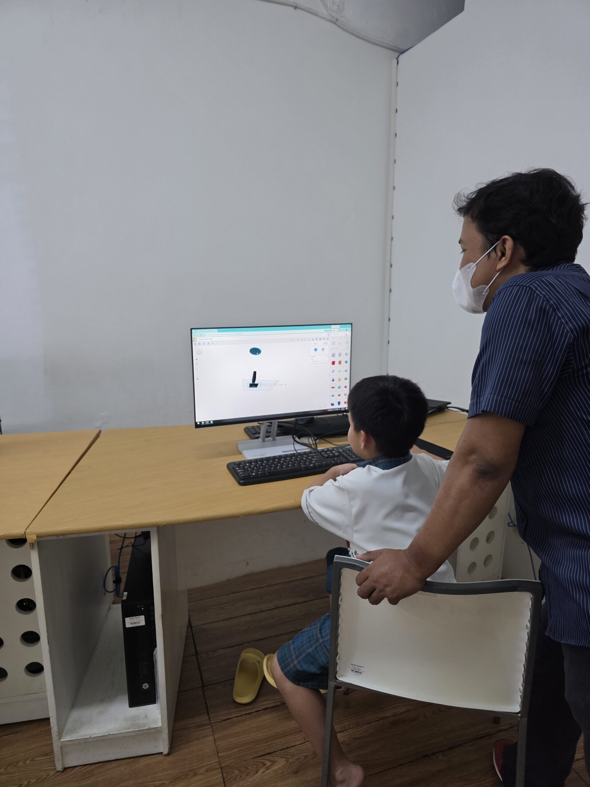 A Digicomp instructor helping a child explore a computer project.