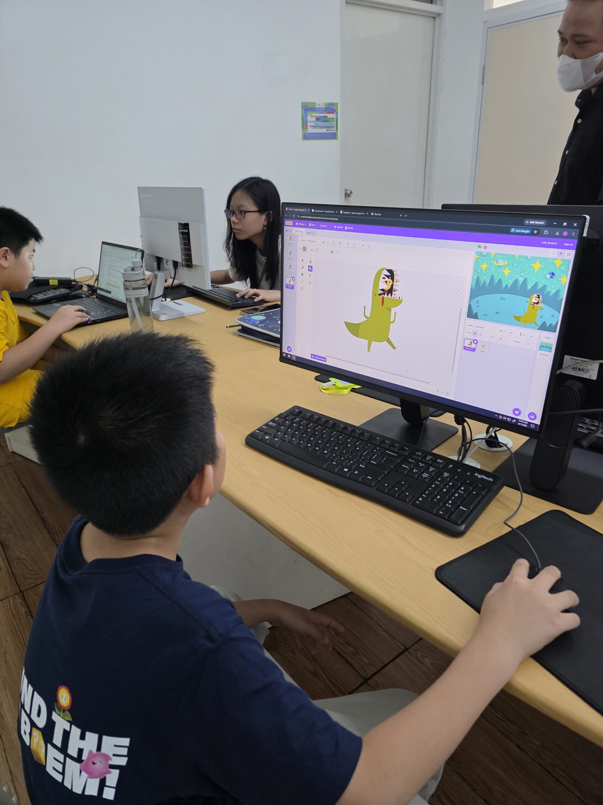 Children exploring a Scratch project with guidance in a Digicomp classroom.